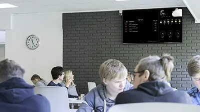 Studentkantine med infoskjerm på veggen